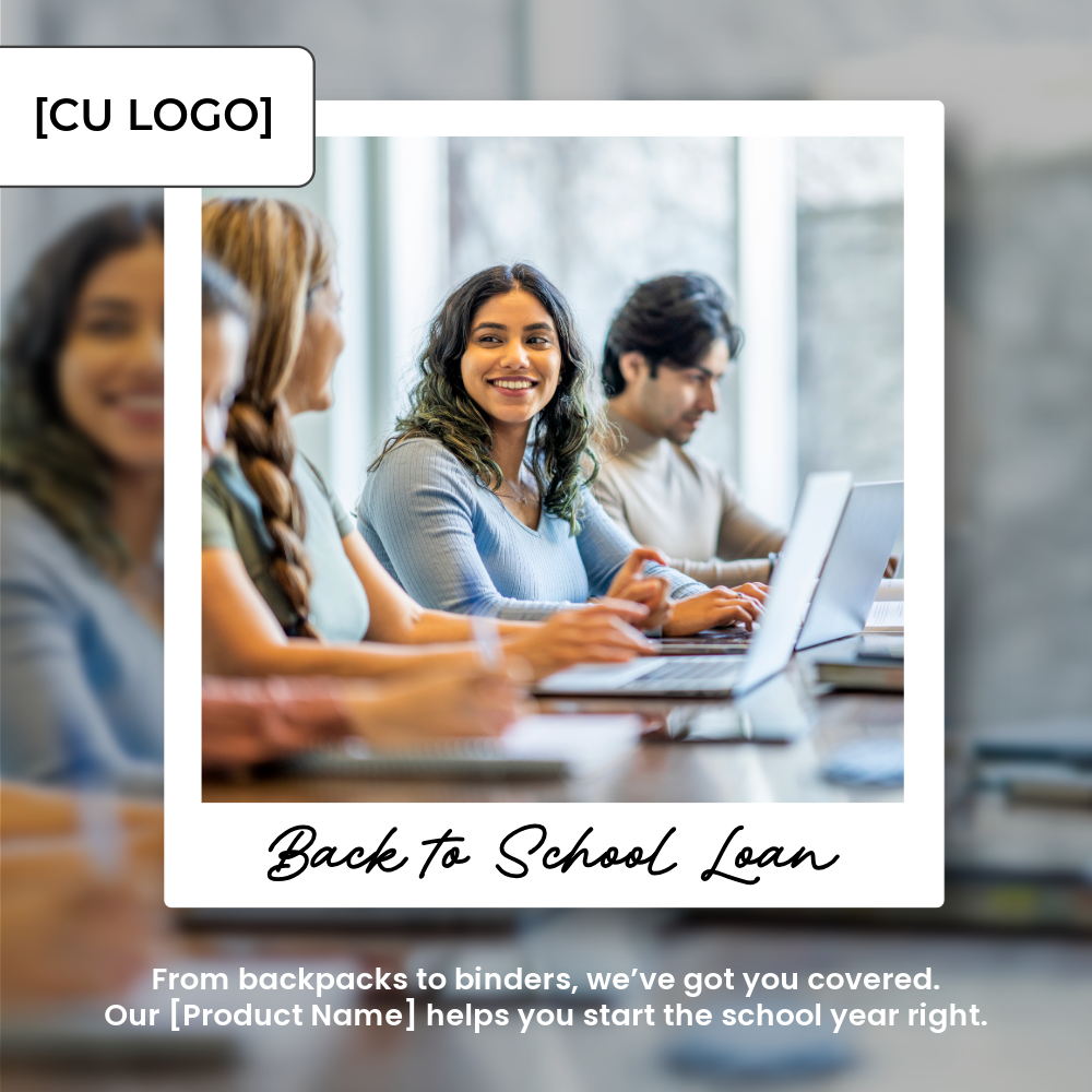 A young woman sits among some peers at a table and is smiling. They all have laptops and some are working.